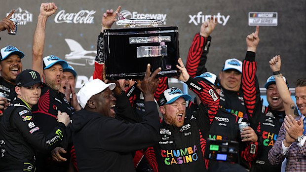 Tyler Reddick and Michael Jordan lift the Harley J. Earl Trophy in victory lane.