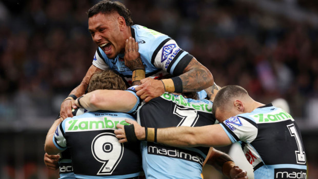 Jesse Ramien jumps on Sione Katoa as the Sharks celebrate a try.