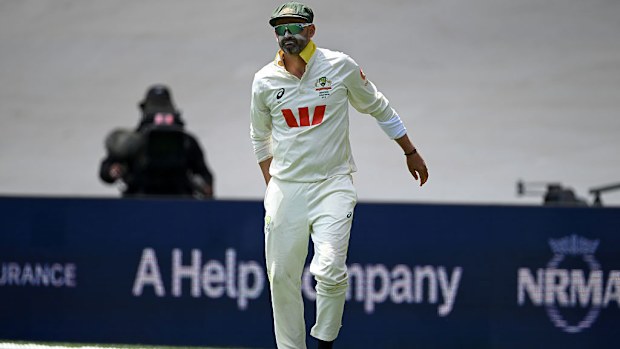 Nathan Lyon of Australia picks an injury while fielding the ball.