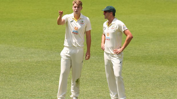 Cameron Green of Australia and Pat Cummins of Australia discuss fielding placements.