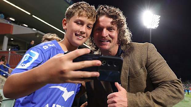 Nick Cummins poses for selfies with young supporters.