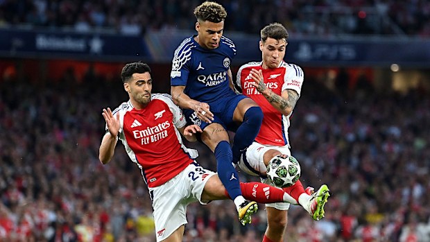 Desire Doue of Paris Saint-Germain is challenged by Mikel Merino and Jakub Kiwior of Arsenal.