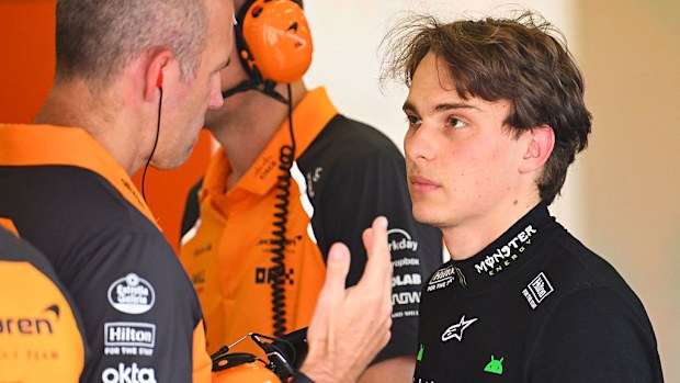 Oscar Piastri talks to his team in the McLaren garage.