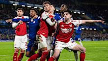 Arsenal and Chelsea players compete for the ball at a corner.