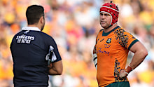 Harry Wilson of the Wallabies speaks with the assistant referee.