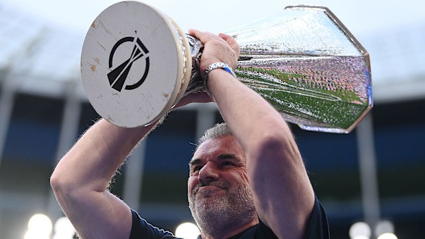 Ange Postecoglou lifts the Europa League trophy as he acknowledges the fans.