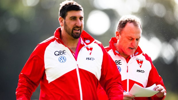 John Longmire, Senior Coach of the Swans and assistant Dean Cox walk from the ground.