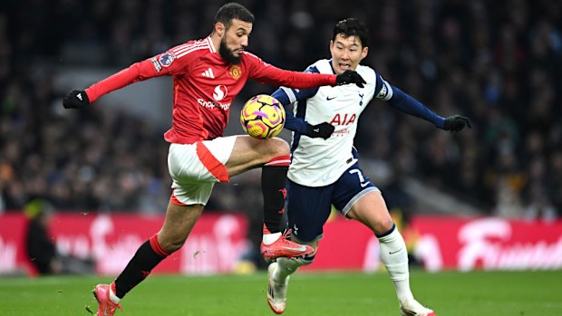 Noussair Mazraoui of Manchester United controls the ball under pressure from Son Heung-Min of Tottenham.