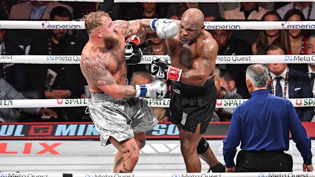 Mike Tyson (in black short) and Jake Paul (in silver short) exchange punches.