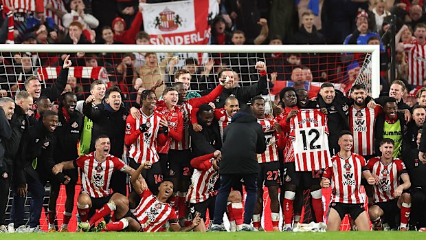 The Sunderland players celebrate victory with a team picture on the pitch.