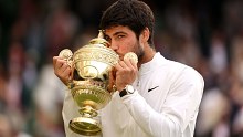Carlos Alcaraz kisses the Wimbledon trophy after his victory. 