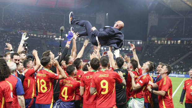 Players of Spain throw coach in the air as the celebrate Euro's win.