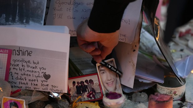 Geoff Payne, the father of former One Direction singer Liam Payne, touches a gel bracelet hanging on a picture of his son while visiting a memorial outside the Casa Sur Hotel where the British pop singer fell to his death from a hotel balcony, in Buenos Aires, Argentina, Friday, Oct. 18, 2024. (AP Photo/Natacha Pisarenko)