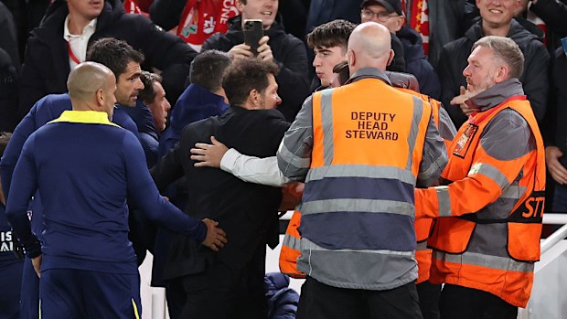 Diego Simeone is restrained as he confronts fans.