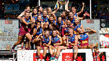 MELBOURNE, AUSTRALIA - DECEMBER 03: The Lions celebrate on the dais after winning during the 2023 AFLW Grand Final match between The North Melbourne Tasmanian Kangaroos and The Brisbane Lions at IKON Park on December 03, 2023 in Melbourne, Australia. (Photo by Michael Willson/AFL Photos via Getty Images)