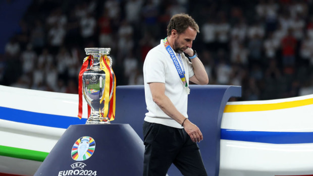 A dejected Gareth Southgate manager walks past the trophy.