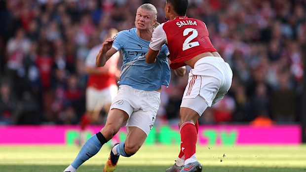 Erling Haaland of Manchester City and William Saliba of Arsenal battle for position.