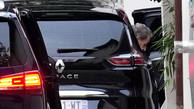 Former French President Nicolas Sarkozy leaves his car as he arrives at his home after being released from prison, Monday, Nov. 10, 2025 in Paris. (AP Photo/Christophe Ena)