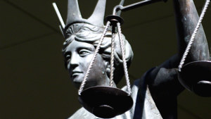 A statue holds the scales of justice outside a Queensland court.