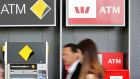 People walking past a row of ATMs belonging to the four big banks.