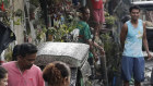 Residents clean ash outside their homes as Taal volcano spews ash on Monday.