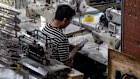 A worker at a garment workshop at Tangbudong Village at night in Guangzhou.