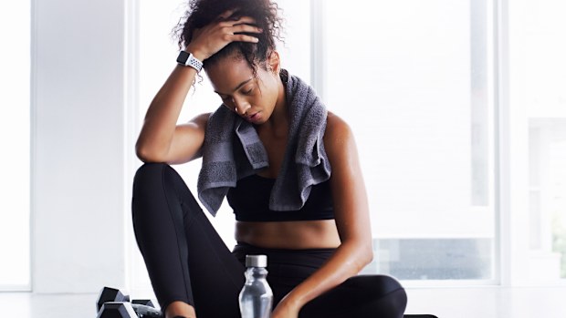 Shot of a young woman taking a break from her workout in a gym