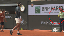 Lorenzo Musetti accidentally kicks a ball at a line judge.