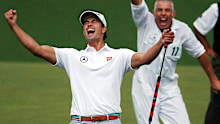 Adam Scott and caddie Steve Williams react after the winning putt at the 2013 Masters. Beaten playoff opponent Angel Cabrera can only watch on despondent in the background, though he had already won a green jacket.