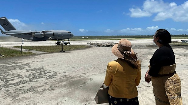 Australian High Commissioner to Tonga, Ms Rachael Moore (left), standing with Tongan Foreign Minister, Fekitamoeloa 'Utoikamanu, watching the arrival of the first Royal Australian Air Force C-17A Globemaster III aircraft from Australia delivering humanitarian assistance.