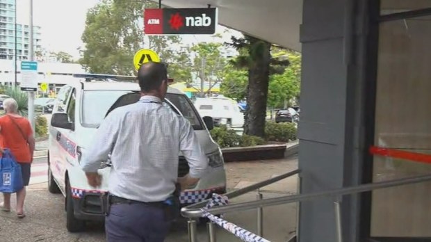 A man is on the run after allegedly robbing a NAB branch on the Gold Coast armed with a knife.