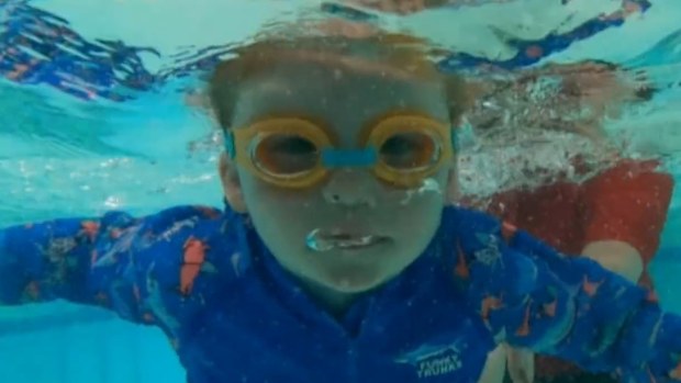 A young child swimming.
