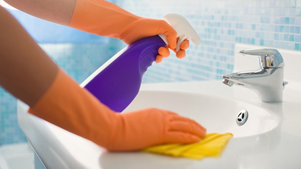 A woman cleaning the bathroom sink