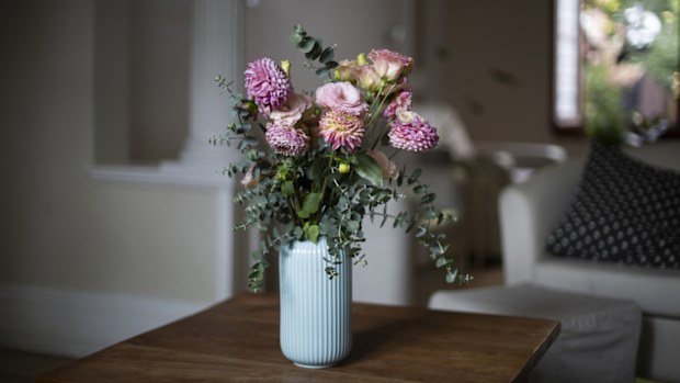 A bunch of flowers in a vase on a coffee table.