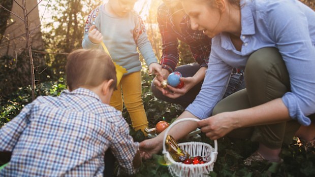 A woman looking for Easter eggs with children