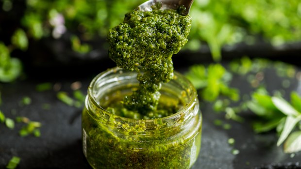 pesto sauce in a spoon, jar with pesto sauce
