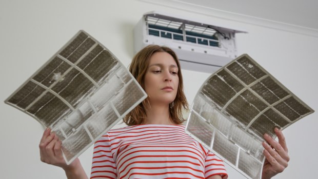 Woman holding very dirty air conditioner filters