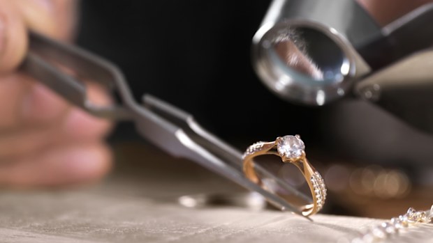 Close-up of a diamond ring being inspected by a jeweler, symbolizing commitment, luxury, and craftsmanship. Ideal for jewelry advertising or romance themes.