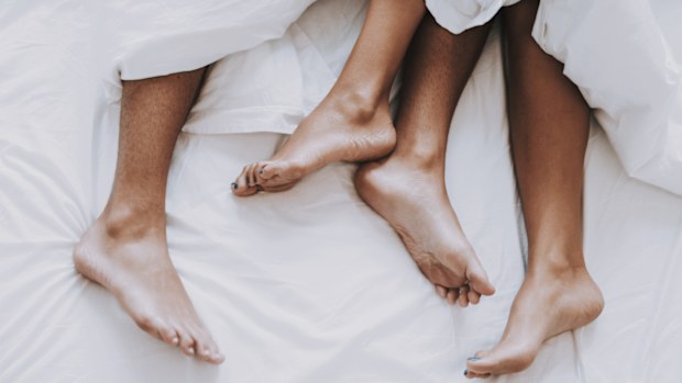 Young couple in underwear lying on bed.