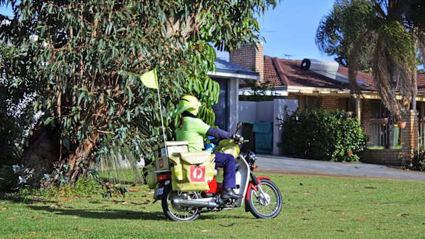 Australia post postman delivering mail on a moped bike. There are 7,950 postal routes serviced by 10,000 "posties" Nationwide.