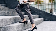 Close up legs of businesswoman hurry up walking she is late time Female business people holding laptop go to office in the modern city foot step on staircase