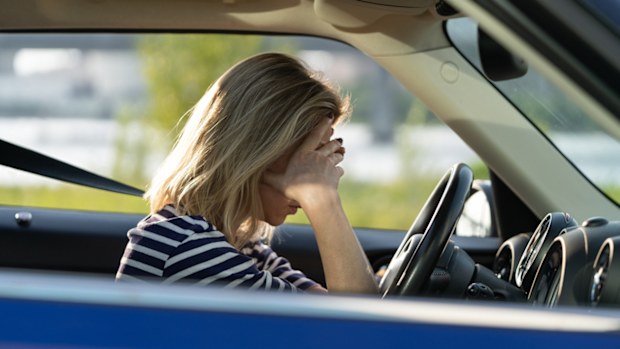 Woman in the car with her head in her hands