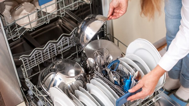 Unloading Dishwasher In The Kitchen