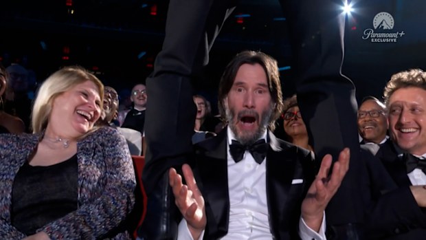 Keanu Reeves straddled by Jonathan Groff