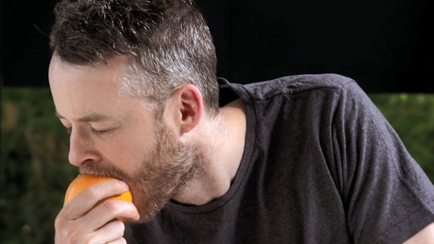Hamish Blake biting into an orange with the skin on, because why not?