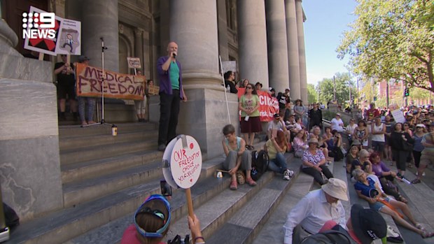 People gather with signs and listen to speeches in Adelaide today.
