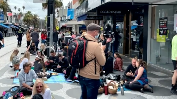 Dozens of protesters lined a St Kilda dining strip this afternoon to demonstrate against rules banning unvaccinated people from entering venues and shops.
