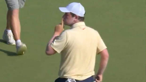 Robert MacIntyre pumps his fist, looks back at the crowd, and puts his index finger to his lips to "shush" a heckler.