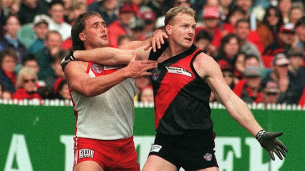Essendon's Dean Wallis fends off Tony Lockett.