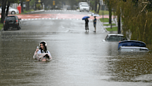 BRISBANE, AUSTRALIA - MARCH 09: A resident walks on a flooded Edmonstone Street in the suburb of Newmarket on March 09, 2025 in Brisbane, Australia. Australia's east coast is experiencing severe weather as ex-Tropical Cyclone Alfred moves south. (Photo by Albert Perez/Getty Images)